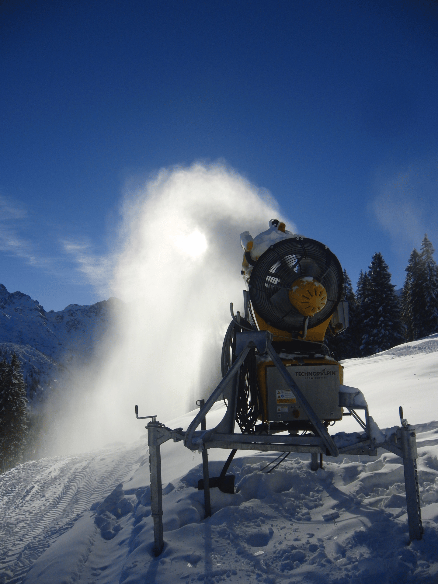 Schneekanone im nächtlichen Einsatz unter klarem Sternenhimmel