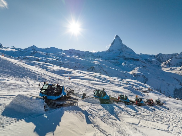 Kolonne von Pistenraupen vor dem Matterhorn