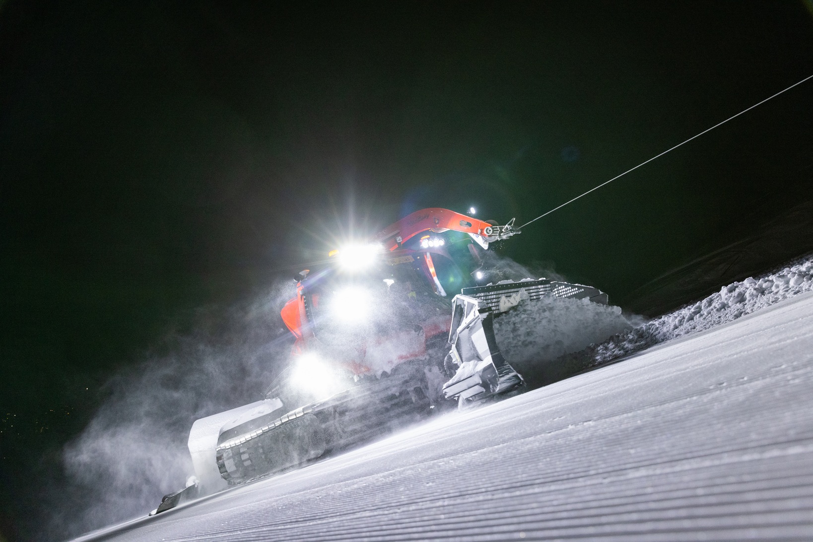 Windenraupe bei Nacht am Steilhang im Scheinwerferlicht