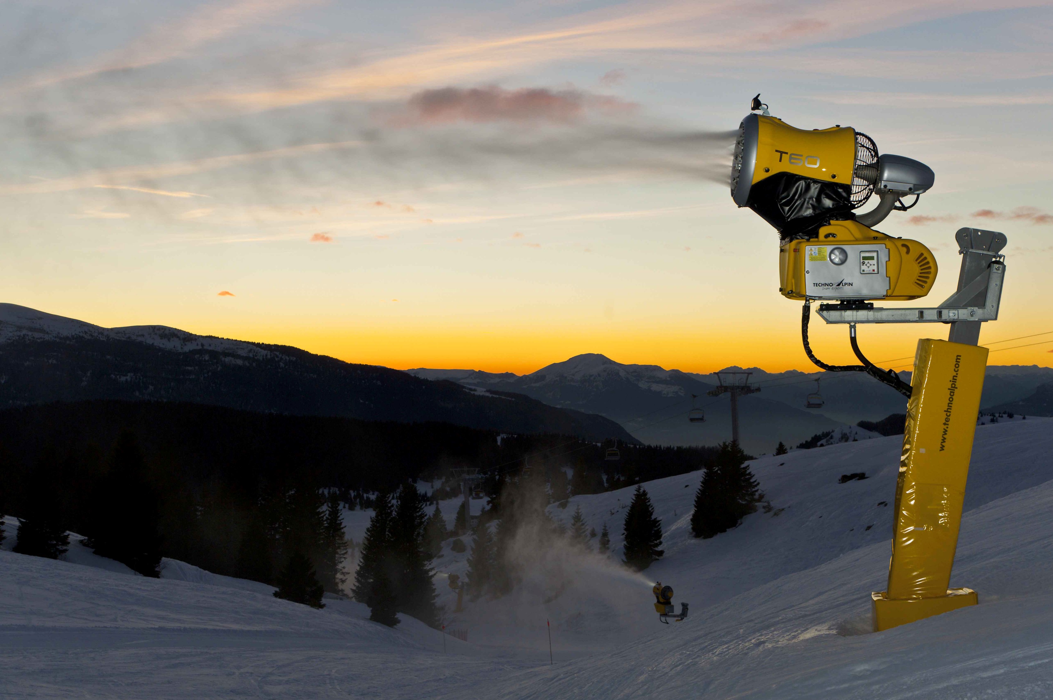 Schneilanze im Betrieb bei Sonnenuntergang über dem Bergpanorama