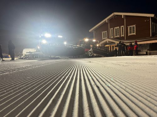 Snow groomer operator carrying out professional slope grooming